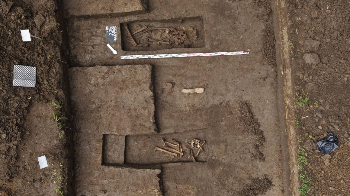 Widok z drona na dwa odsłonięte groby wojenne podczas badań archeologicznych w Szczawnem