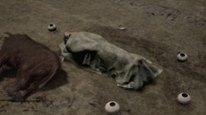 Rekonstrukcja pochówku kultury amfor kulistych w Kaliszanach: zmarły przykryty tkaniną leży na ziemi, obok widoczne są naczynia ceramiczne i szczątki zwierzęcia.