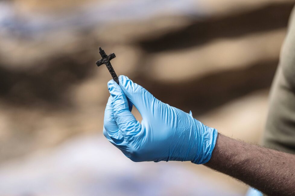 Metalowy krucyfiks wydobyty z warstwy spalenizny – ślad, który pozostał po przeprowadzeniu Aktion 1005 (fot. D. Frymark, zbiory IPN)