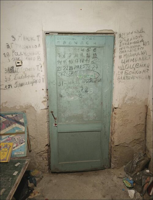 Drzwi z zaznaczonym kalendarzem odliczającym dni do wycofania wojsk rosyjskich i powrotu sił ukraińskich; po bokach zapisano nazwiska osób zabitych w wsi oraz zmarłych w piwnicy, 1 marca 2025 (fot. G. Kiarszys).