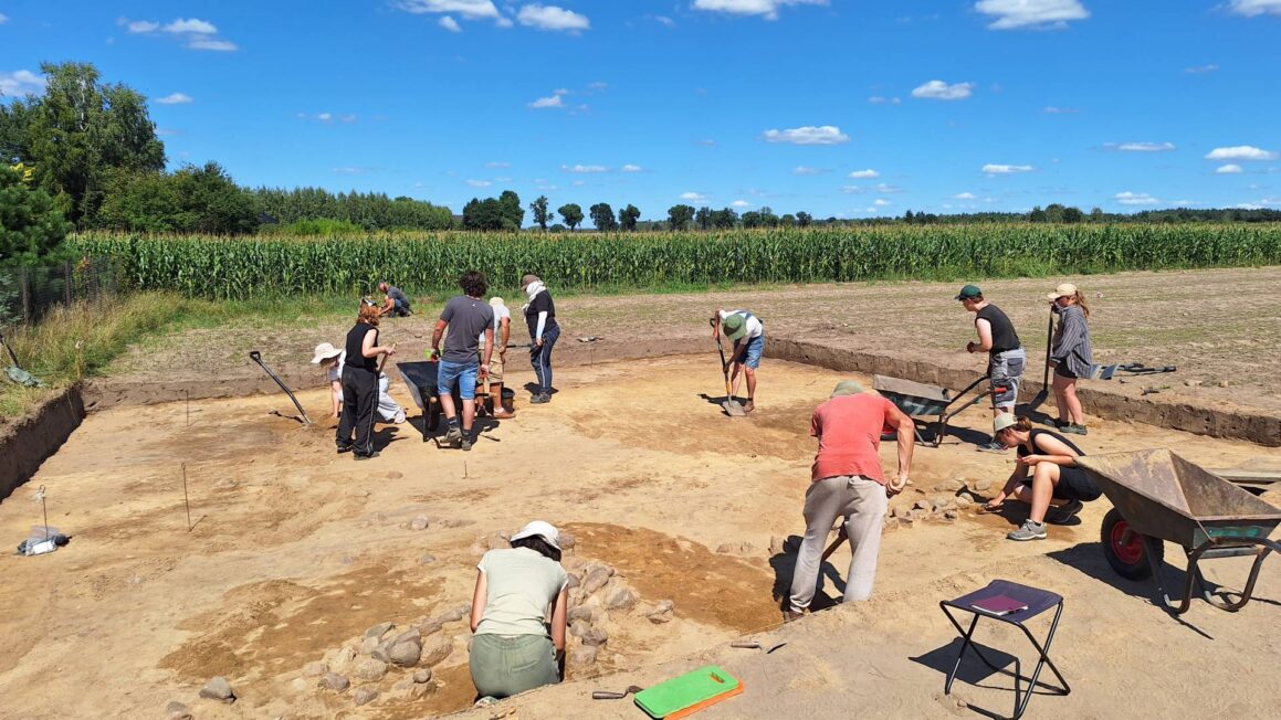 Archeolodzy podczas badań cmentarzyska w Kwiatkowicach, z kamiennymi konstrukcjami grobów widocznymi w wykopie