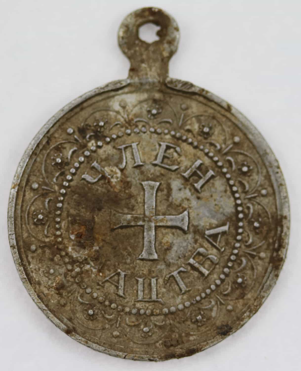 Rewers aluminiowego medalionu należącego do członka Bractwa Matki Bożej Nieustającej Pomocy, odnaleziony na terenach poobozowych w Łambinowicac