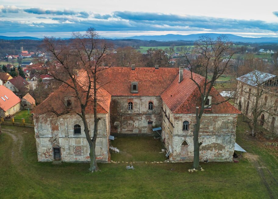 Zrujnowany pałac w Wierzbnej widziany z lotu ptaka, z trzema skrzydłami otaczającymi dziedziniec.